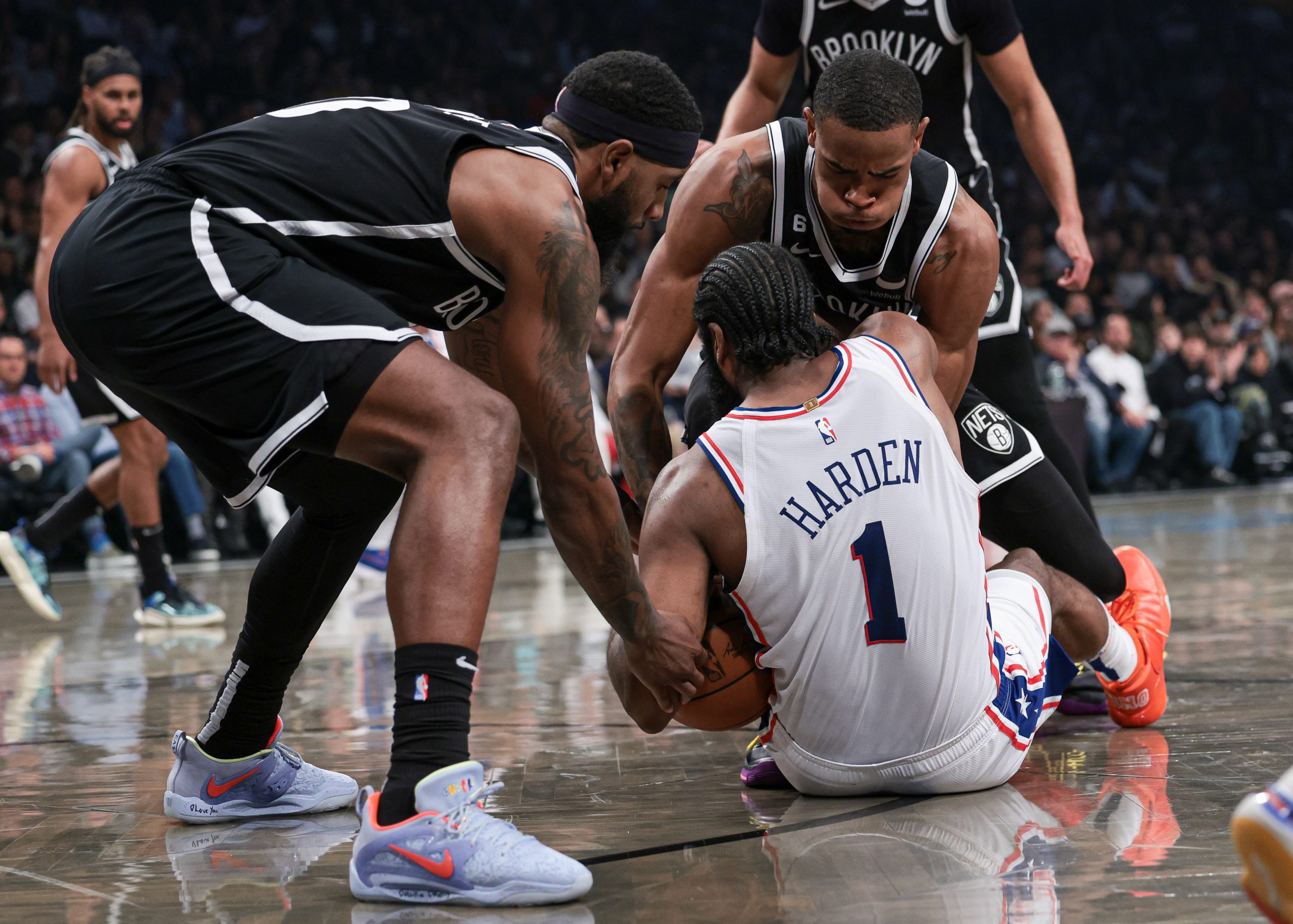 Nicholas Claxton and Royce O'Neale attempting to steal the ball from James Harden