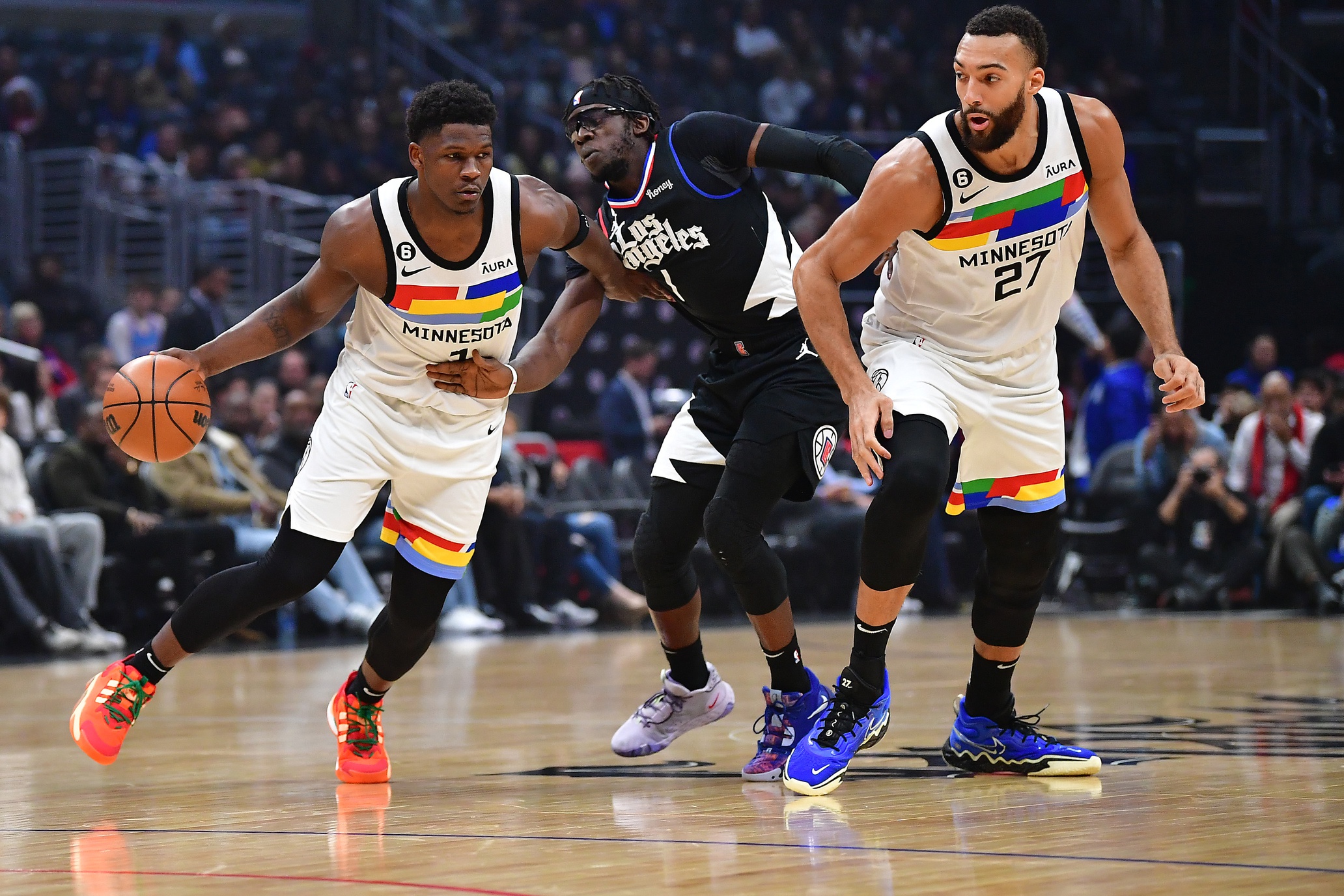 Minnesota Timberwolves guard Anthony Edwards (1) moves the ball as center Rudy Gobert (27) provides coverage against Los Angeles Clippers guard Reggie Jackson (1) during the first half at Crypto.com Arena.