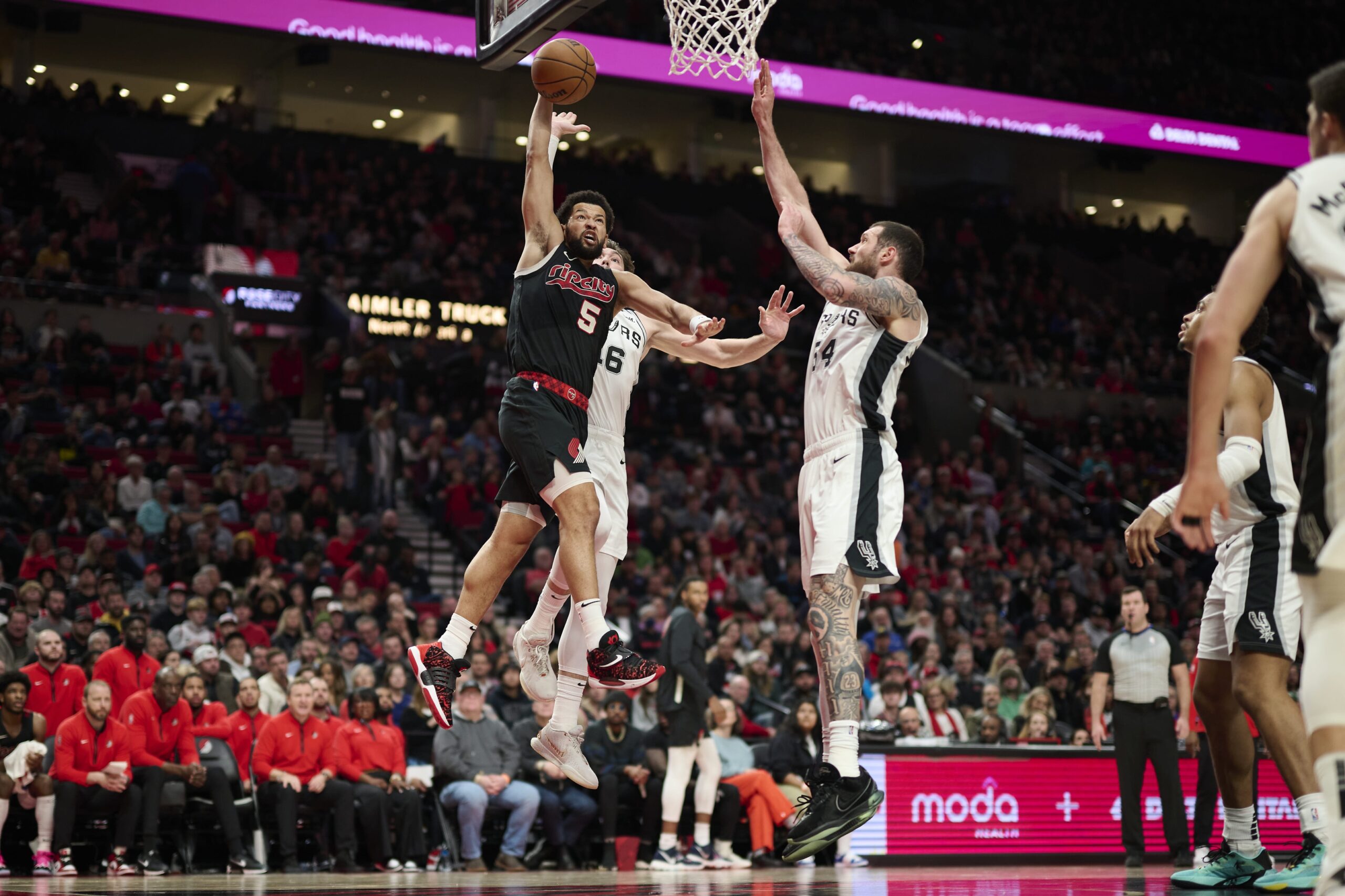 Dec 29, 2023; Portland, Oregon, USA; Portland Trail Blazers guard Skylar Mays (5) slam dunks the basketball during the second half against San Antonio Spurs forward Cedi Osman (16) and forward Sandro Mamukelashvili (54) at Moda Center. Mandatory Credit: Troy Wayrynen-USA TODAY Sports