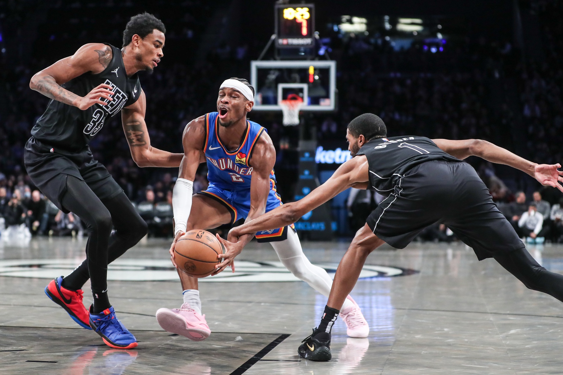 Oklahoma City Thunder guard Shai Gilgeous-Alexander (2) drives against Brooklyn Nets center Nic Claxton (33) and forward Mikal Bridges (1) in the third quarter at Barclays Center.