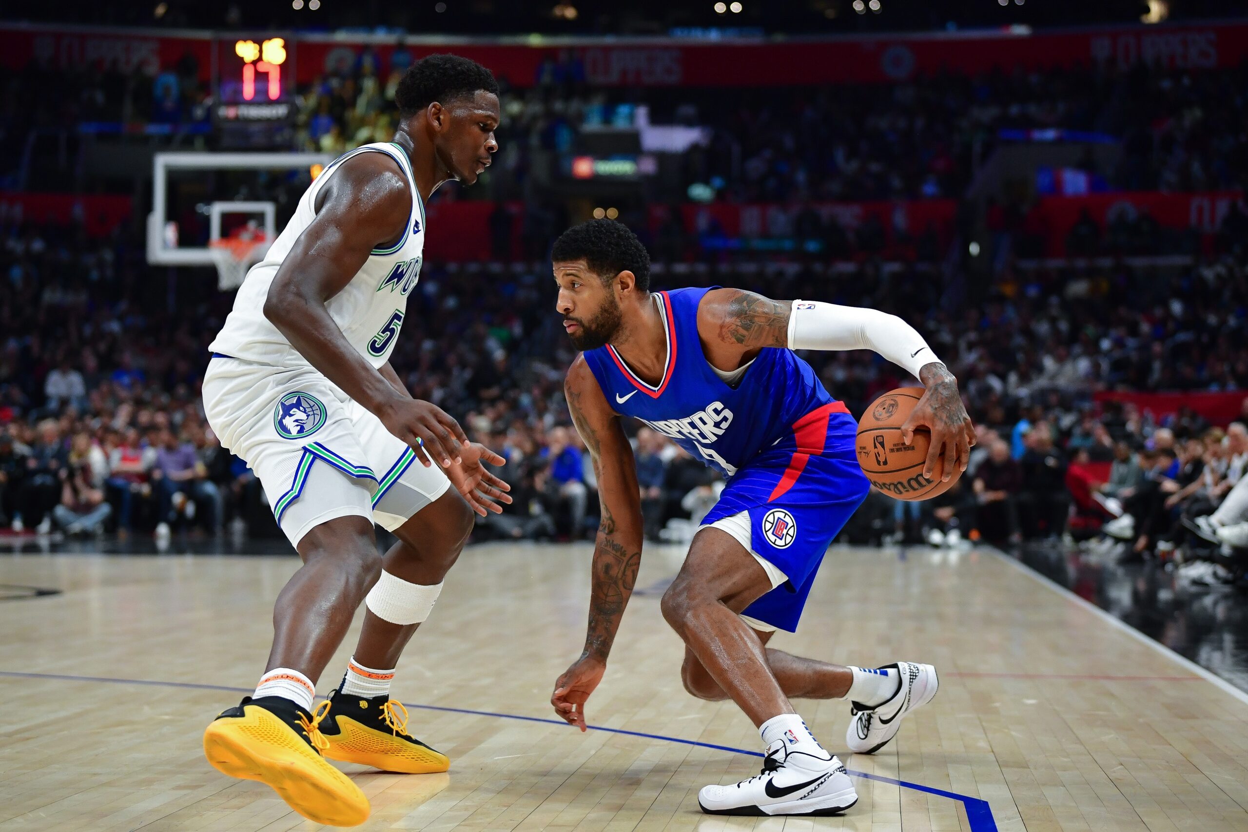 Feb 12, 2024; Los Angeles, California, USA; Los Angeles Clippers forward Paul George (13) moves the ball against Minnesota Timberwolves guard Anthony Edwards (5) during the second half at Crypto.com Arena. Mandatory Credit: Gary A. Vasquez-USA TODAY Sports