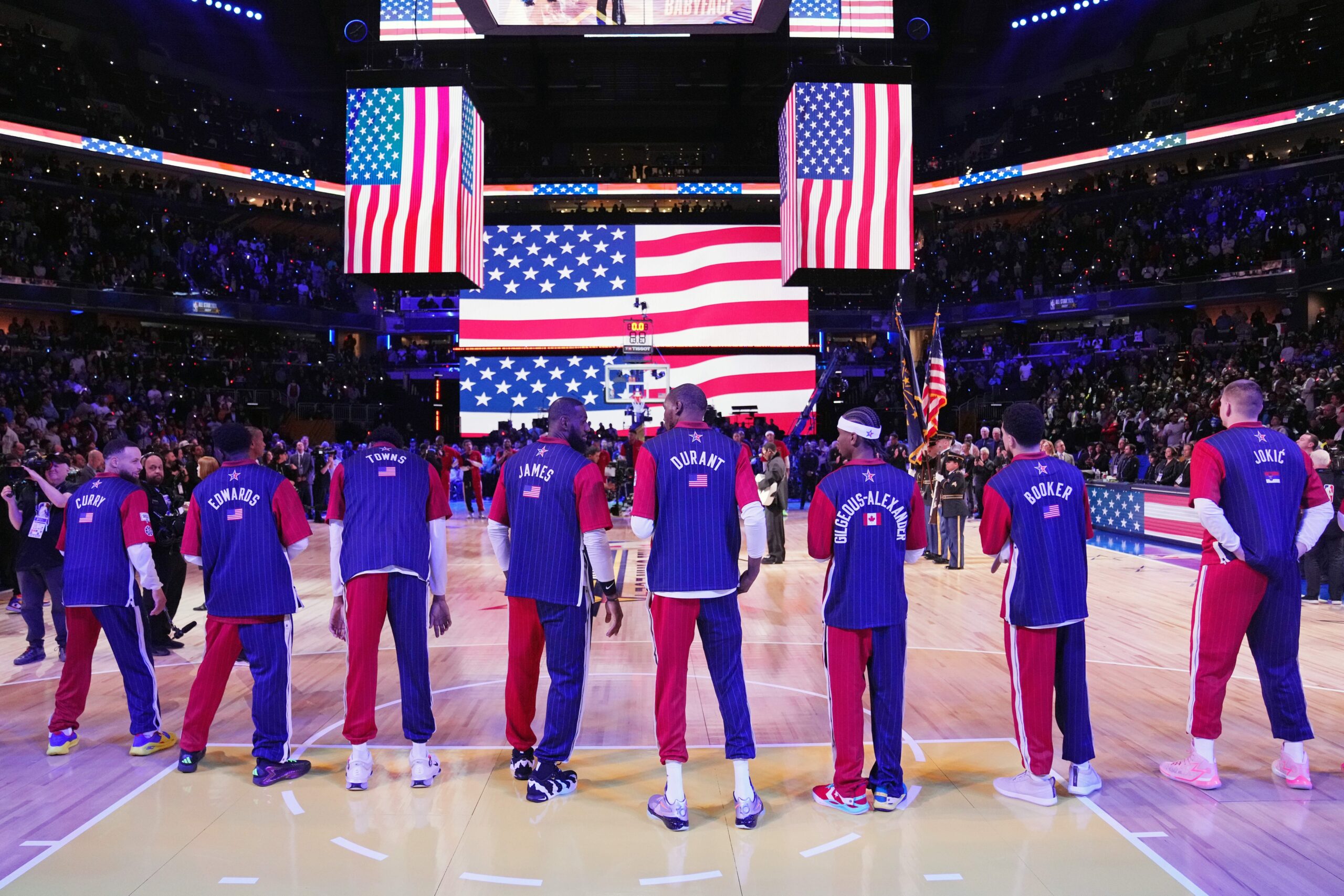 NBA players stand in front of the USA flag at All-Star Game