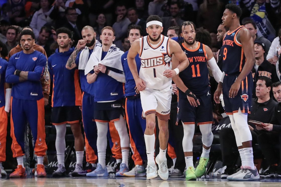 Phoenix Suns guard Devin Booker in front of the New York Knicks bench