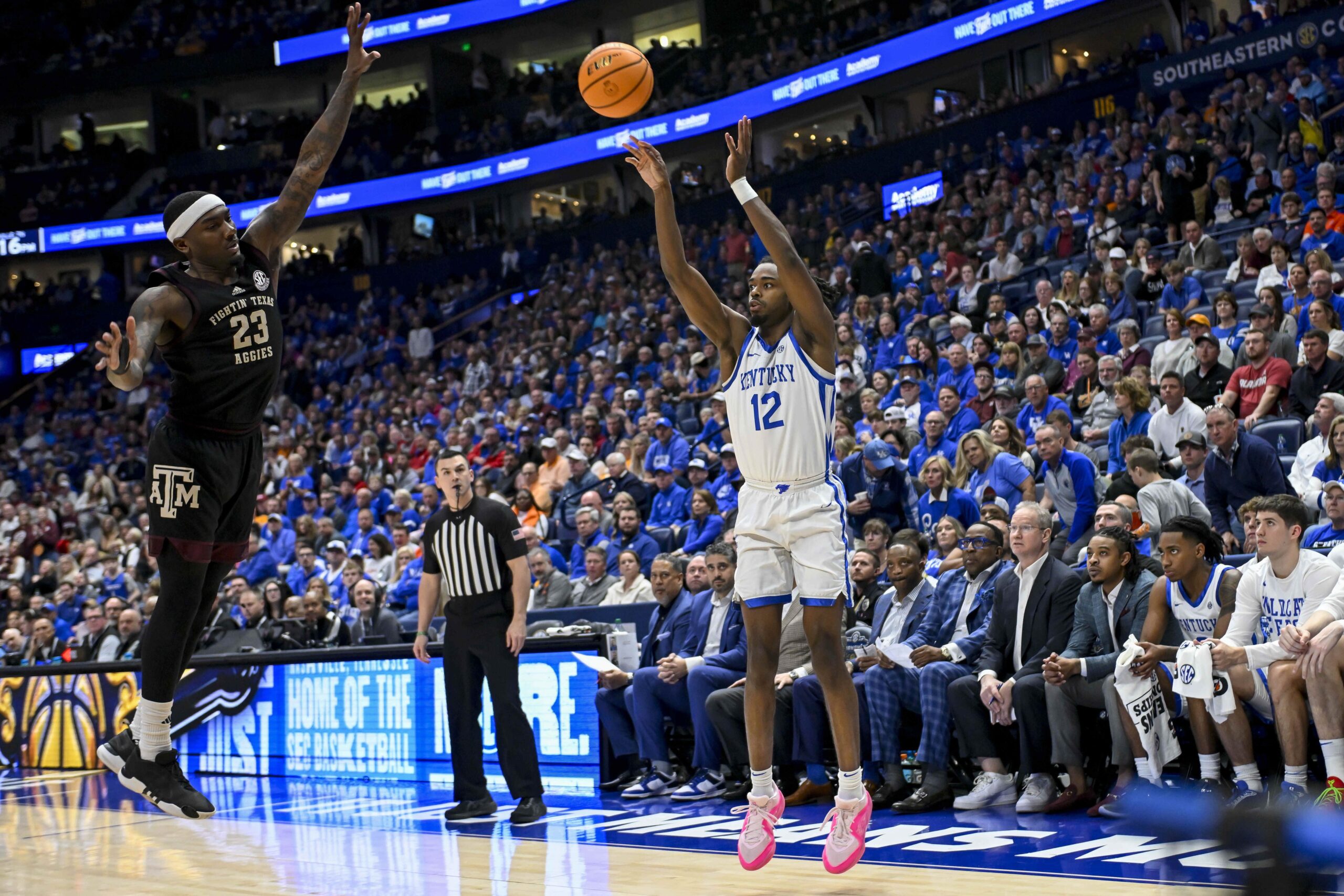 Mar 15, 2024; Nashville, TN, USA; Kentucky Wildcats guard Antonio Reeves (12) shoots a three over Texas A&M Aggies guard Tyrece Radford (23) during the second half at Bridgestone Arena. Mandatory Credit: Steve Roberts-USA TODAY Sports