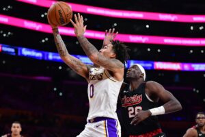 Jan 21, 2024; Los Angeles, California, USA; Los Angeles Lakers guard Jalen Hood-Schifino (0) moves to the basket ahead of Portland Trail Blazers center Duop Reath (26) during the second half at Crypto.com Arena. Mandatory Credit: Gary A. Vasquez-USA TODAY Sports