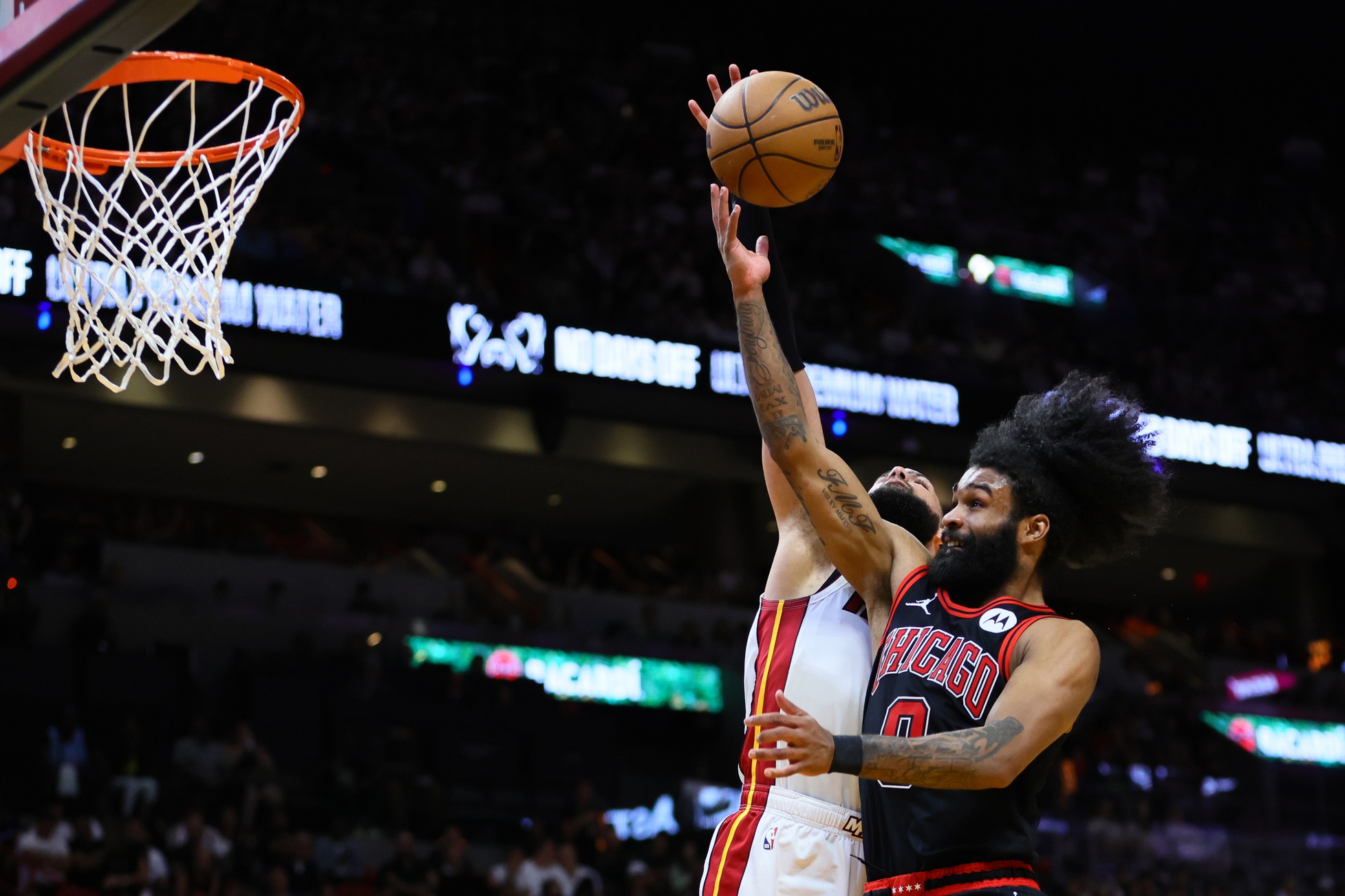 Apr 19, 2024; Miami, Florida, USA; Miami Heat forward Caleb Martin (16) blocks a shot against Chicago Bulls guard Coby White (0) in the second quarter during a play-in game of the 2024 NBA playoffs at Kaseya Center. Mandatory Credit: Sam Navarro-USA TODAY Sports