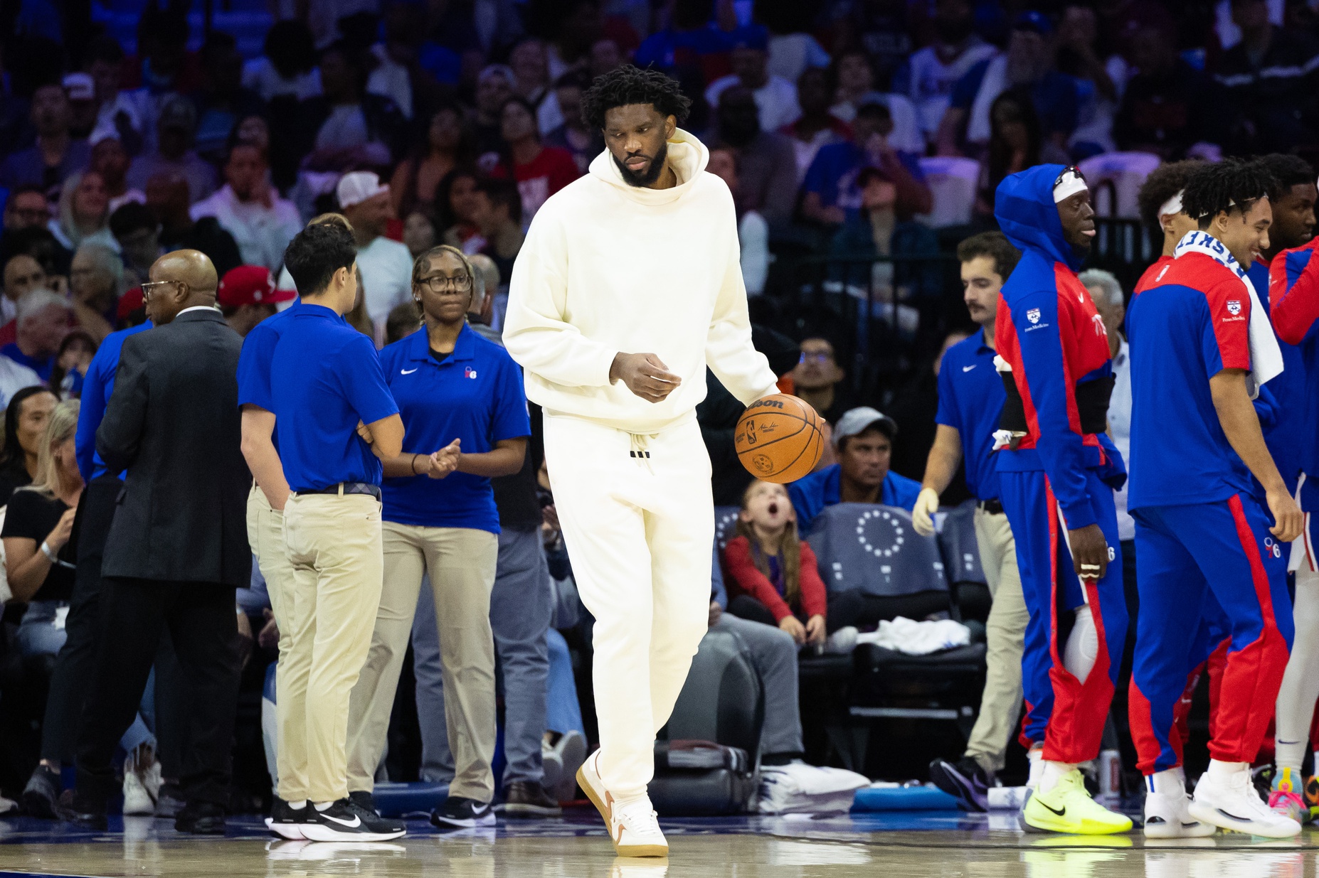 Philadelphia 76ers center Joel Embiid in plain clothes dribbles the ball during a timeout in the second quarter against the Milwaukee Bucks at Wells Fargo Center.