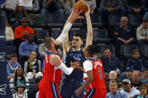 NBA: Memphis Grizzlies rookie Zach Edey (14) handles the ball as Washington Wizards center Jonas Valanciunas (17) and rookie Bub Carrington (8) defend