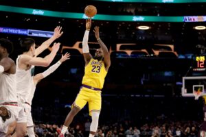 Los Angeles Lakers forward LeBron James (23) shoots the ball over defenders’ outstretched hands