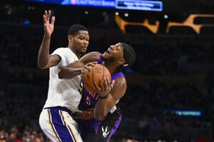 Nov 10, 2024; Los Angeles, California, USA; Los Angeles Lakers forward Cam Reddish (5) blocks Toronto Raptors guard Immanuel Quickley (5) during the second half at Crypto.com Arena. Mandatory Credit: Jonathan Hui-Imagn Images