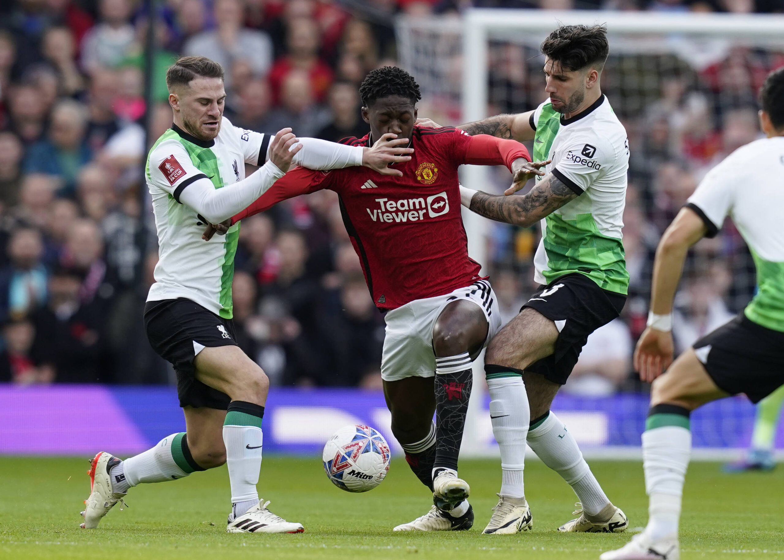 Liverpool's Alexis Mac Allister and Dominik Szoboszlai fight for the ball with Manchester United's Kobbie Mainoo.