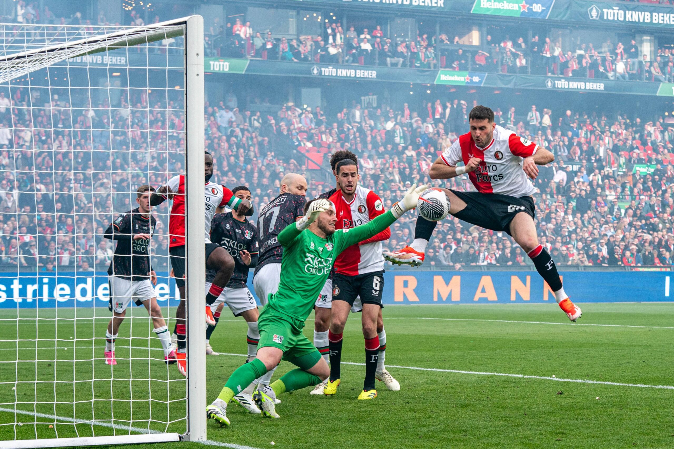 Santiago Gimenez challenges for the ball against Jasper Cillessen