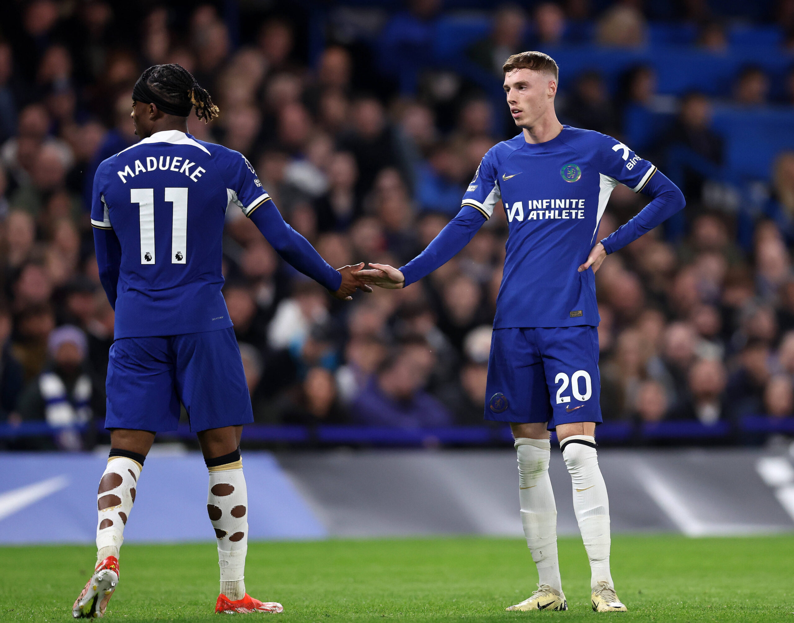 Cole Palmer and Noni Madueke slap hands as one leaves the pitch