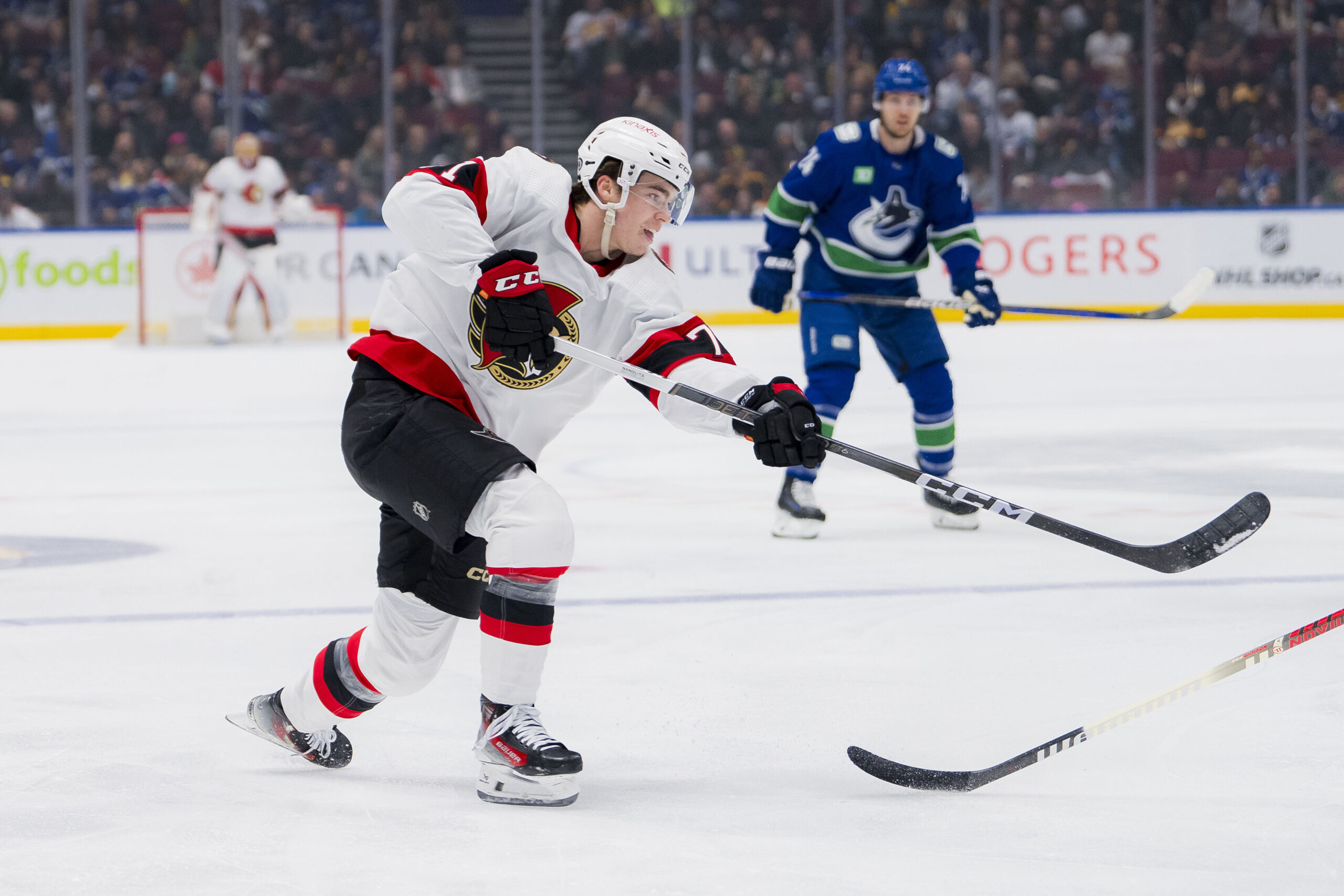 Ridly Greig shoots puck against Vancouver Canucks