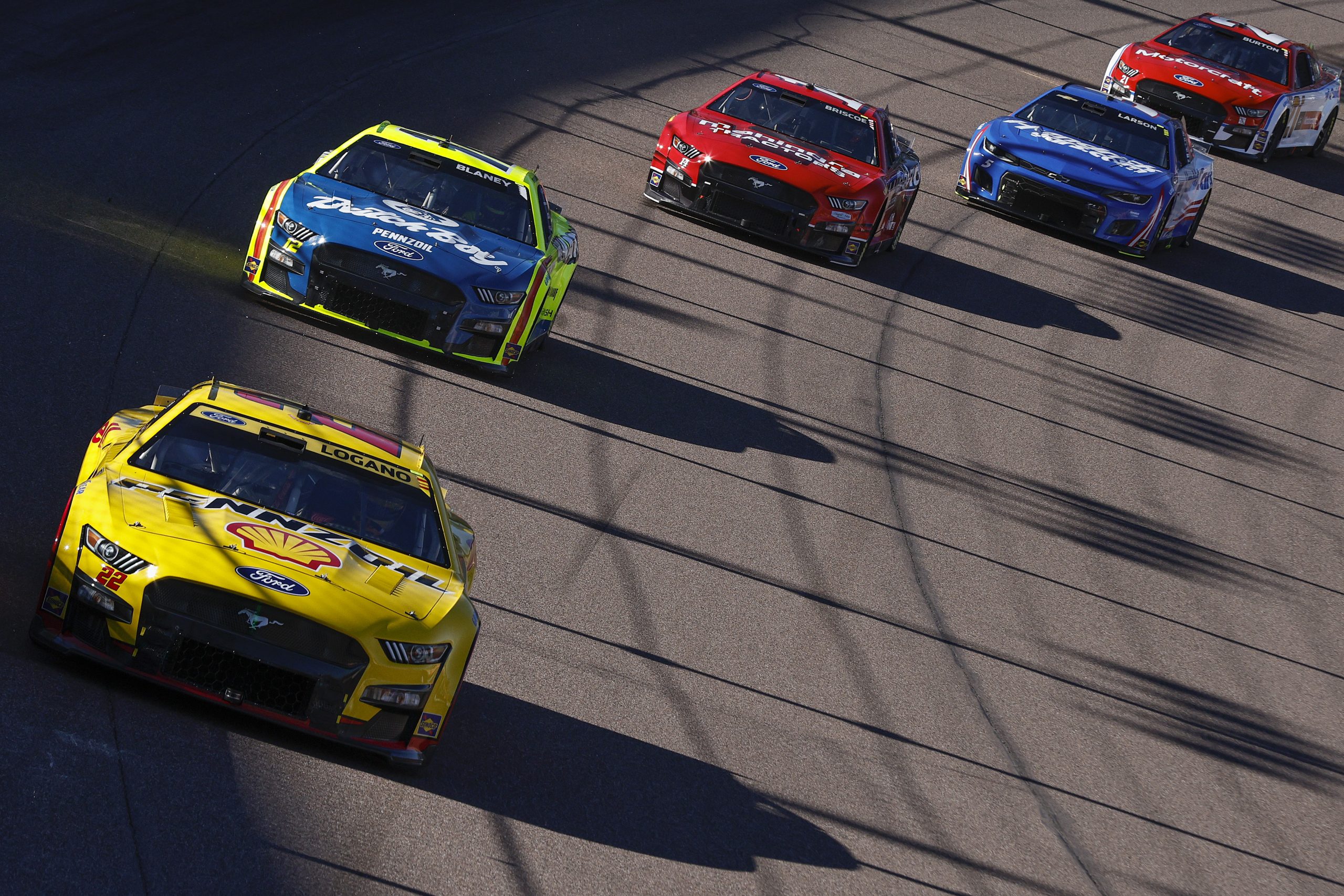 AVONDALE, ARIZONA - NOVEMBER 06: Joey Logano, driver of the #22 Shell Pennzoil Ford, Ryan Blaney, driver of the #12 Menards/Dutch Boy Ford, Chase Briscoe, driver of the #14 Mahindra Tractors Ford, Kyle Larson, driver of the #5 HendrickCars.com Chevrolet, and Harrison Burton, driver of the #21 Motorcraft/Quick Lane Ford, race race during the NASCAR Cup Series Championship at Phoenix Raceway on November 06, 2022 in Avondale, Arizona. (Photo by Sean Gardner/Getty Images)