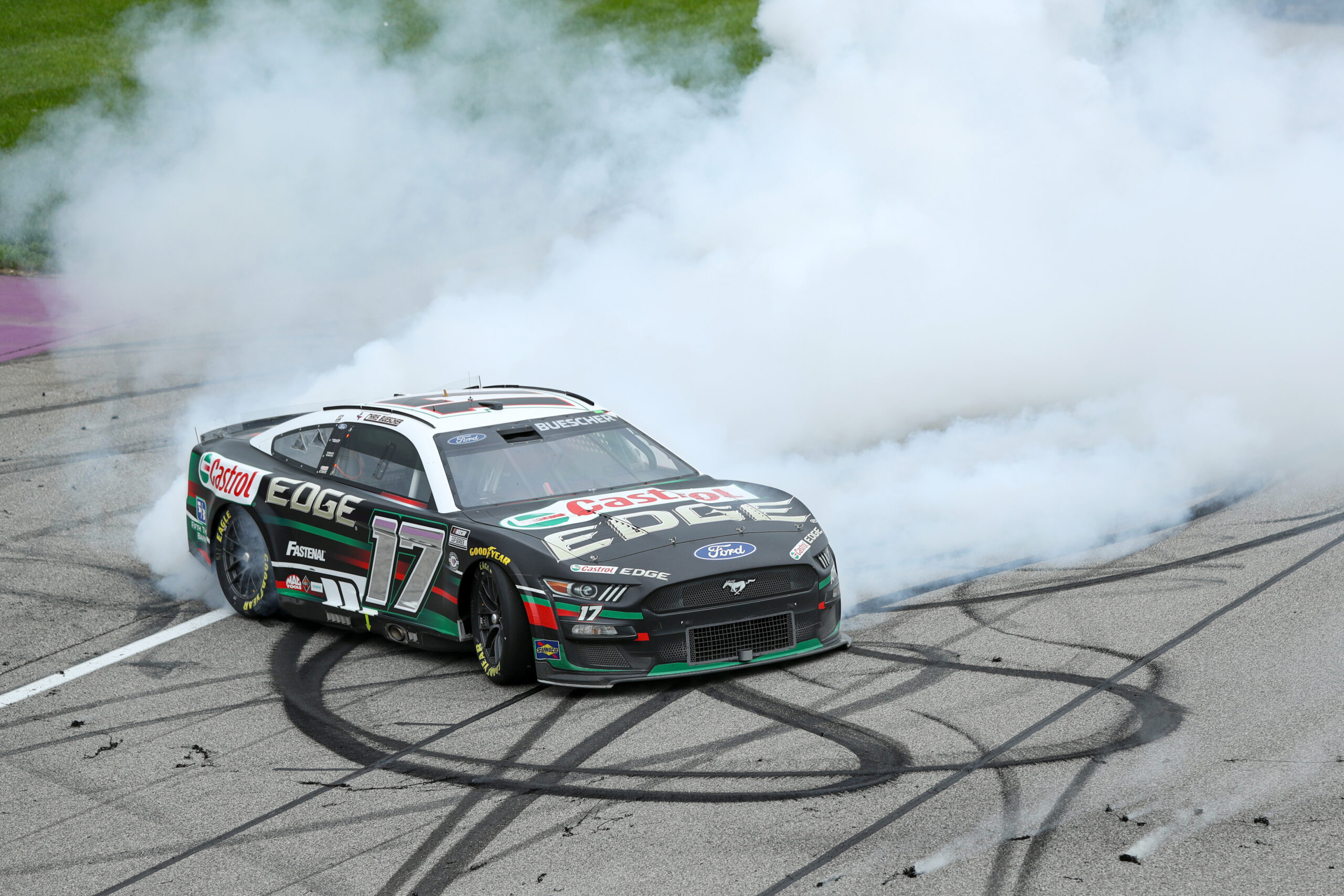 BROOKLYN, MICHIGAN - AUGUST 07: Chris Buescher, driver of the #17 Castrol Edge Ford, celebrates with a burnout after winning the NASCAR Cup Series FireKeepers Casino 400 at Michigan International Speedway on August 07, 2023 in Brooklyn, Michigan. (Photo by Meg Oliphant/Getty Images)