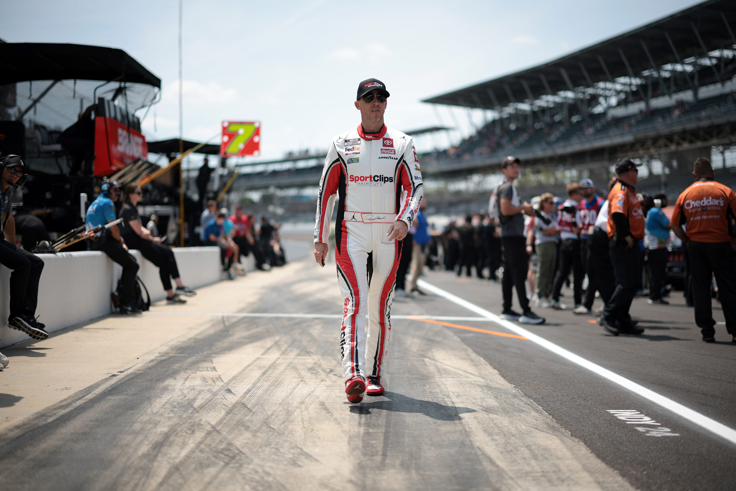 INDIANAPOLIS, INDIANA - JULY 20: Denny Hamlin, driver of the #11 Sport Clips Haircuts Toyota, walks the grid during qualifying for the NASCAR Cup Series Brickyard 400 at Indianapolis Motor Speedway on July 20, 2024 in Indianapolis, Indiana. (Photo by James Gilbert/Getty Images)