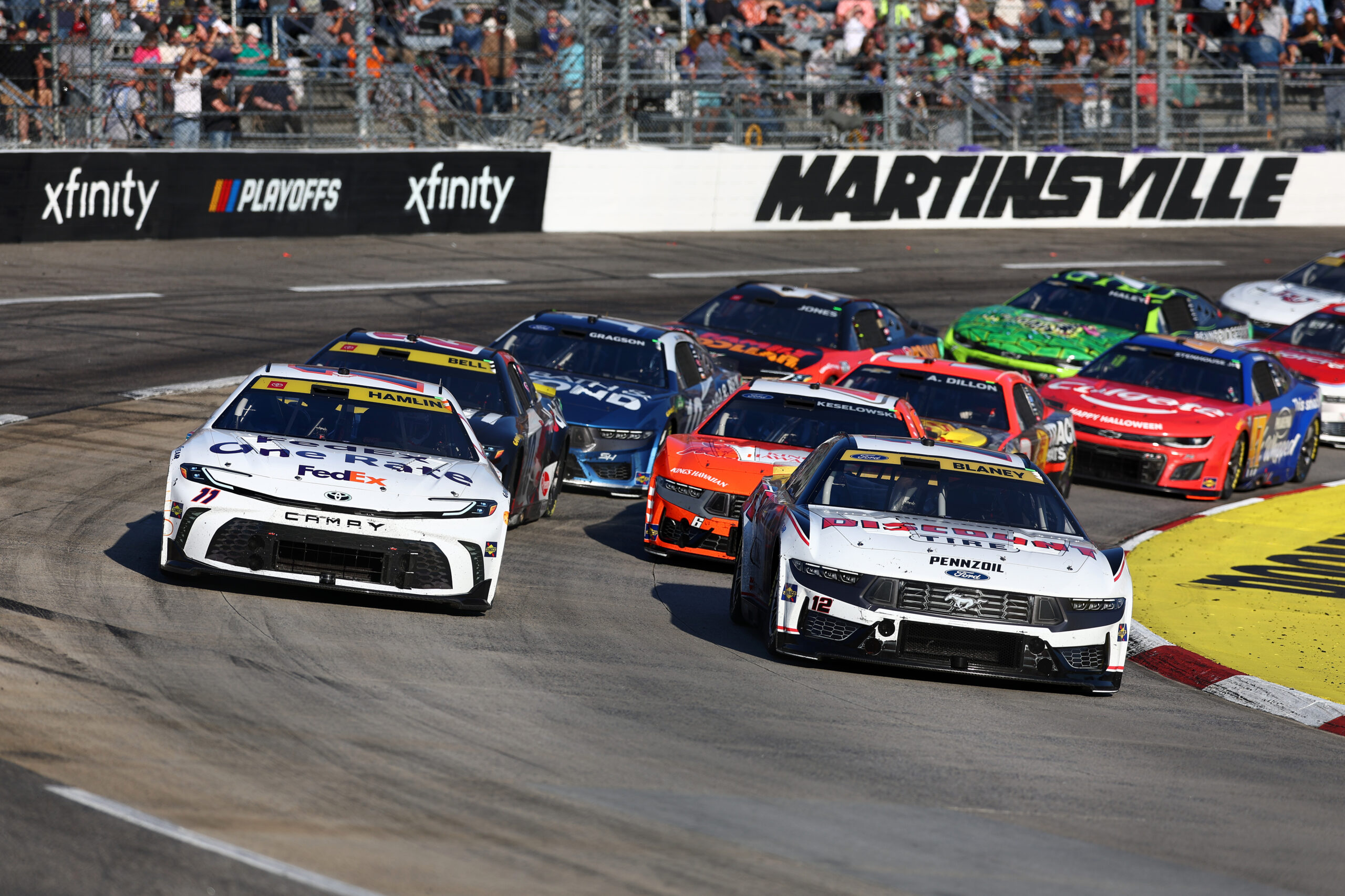 MARTINSVILLE, VIRGINIA - NOVEMBER 03: Denny Hamlin, driver of the #11 FedEx One Rate Toyota, and Ryan Blaney, driver of the #12 Discount Tire Ford, race during the NASCAR Cup Series Xfinity 500 at Martinsville Speedway on November 03, 2024 in Martinsville, Virginia. (Photo by David Jensen/Getty Images)